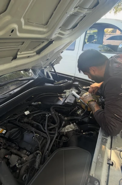 Bebo working under the hood of a customer's vehicle